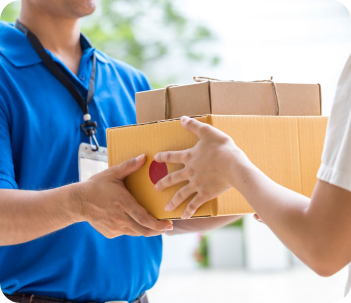 A picture of a person handing 2 boxes to a man in blue colored shirt.